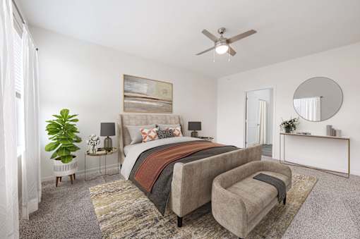 A bedroom with a large bed and a ceiling fan.