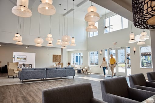 A group of people are walking through a large, open lobby area.
