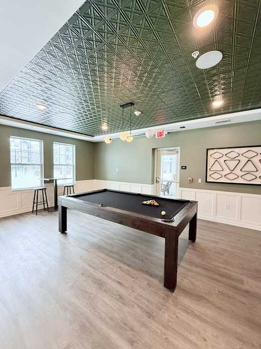 A pool table is in the middle of the room.