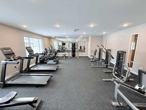 A spacious gym with treadmills, elliptical machines, and other exercise equipment.