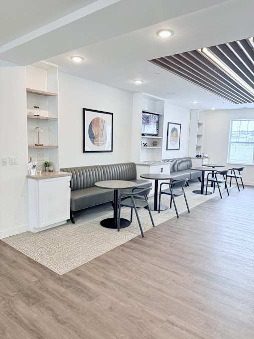 A modern living room with a grey sofa and a white sideboard.