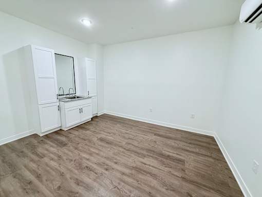 A room with a wooden floor and white walls.