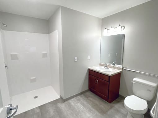 A bathroom with a toilet, sink, and shower.
