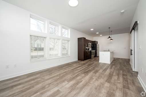 A room with wooden flooring and a large window.