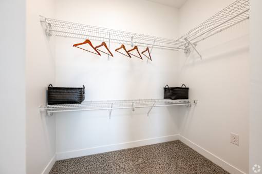A white wall with a metal rack and two black bags.