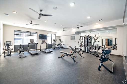 A spacious gym with a variety of equipment including treadmills, weights, and exercise machines.