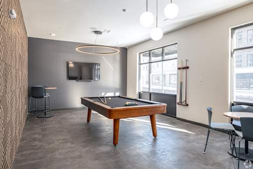 A room with a pool table and a television.