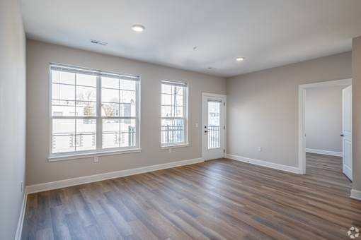 A room with wooden floors and two windows.