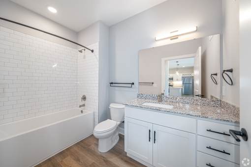 A white bathroom with a toilet, sink, and bathtub.
