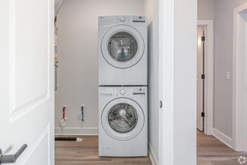 A white front loading washing machine in a laundry room.
