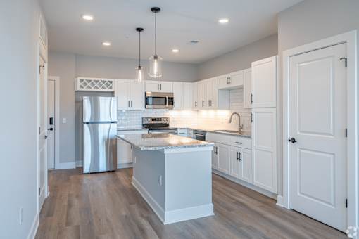 A modern kitchen with white cabinets and a central island.