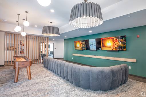 A room with a grey couch and a wooden table.