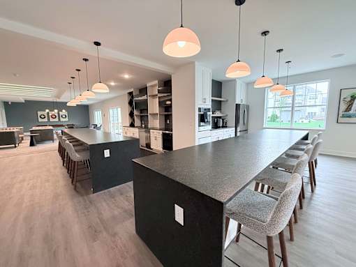 A modern kitchen with a long island and bar stools.