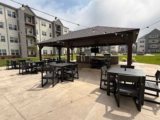 A patio with a table and chairs under a roof.