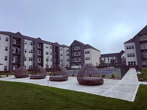 Apartment complex with tennis court and pavilions.