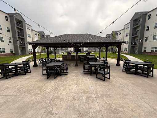 A gazebo with tables is surrounded by apartment buildings.