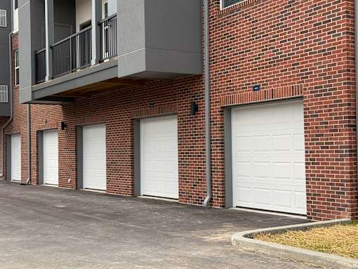 A row of garage doors on a brick building.