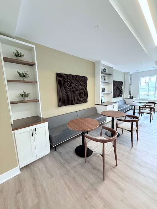 A modern dining area with a wooden table and chairs.