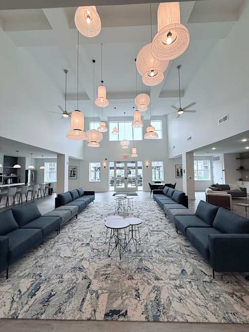 A large open space with a long marble table and couches.