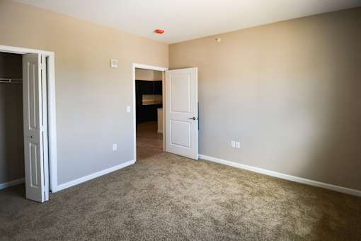 A room with a white door and a carpeted floor.at Union at 16th, Indianapolis Indiana