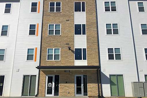 A building with a brown brick facade and white siding.at Union at Crescent, Bloomington, IN 47404  
