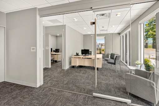 Modern office reception area with glass doors at Union at Rivers Edge Apartments, Iowa