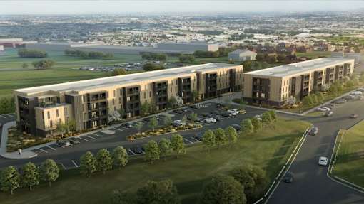 A modern building complex with a parking lot in front at Union at the Marina, Dubuque, IA.