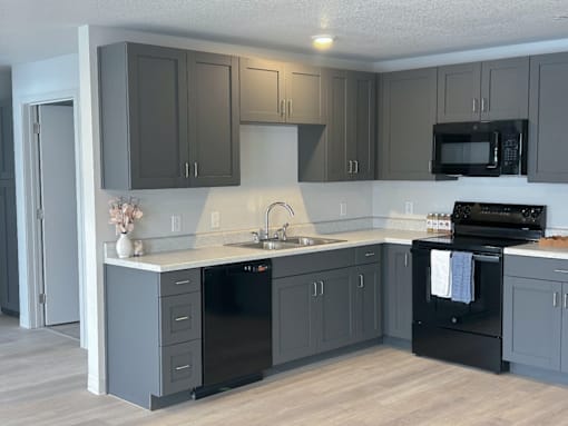 A kitchen with black appliances and cabinets at Union at Rivers Edge Apartments, Des Moines