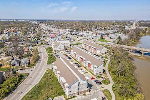 A river flows through a town with apartment buildings on the right at Union at 16th, Indianapolis, IN