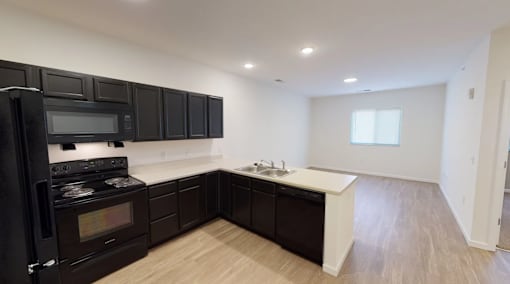 A kitchen with black cabinets and a white countertop.at Union at 16th, Indianapolis, 46222