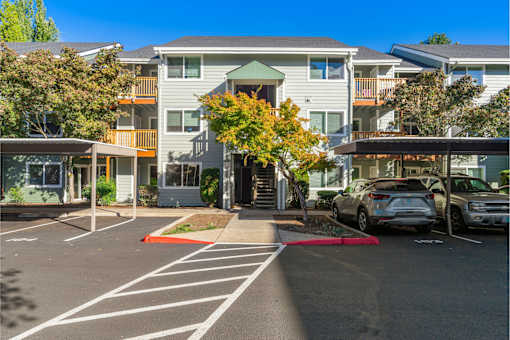 A parking lot with cars and apartment buildings in the background.