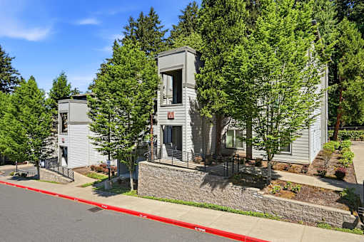 A grey building with a red line on the sidewalk in front of it.