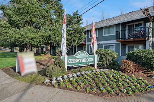 A sign for Crestbrook is in front of a building.