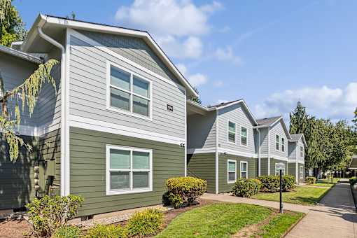 A row of houses with green and grey siding.