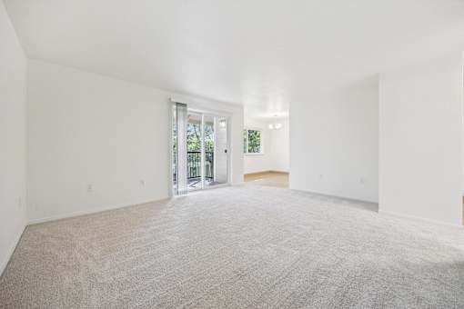 A large, empty room with a carpeted floor and white walls.
