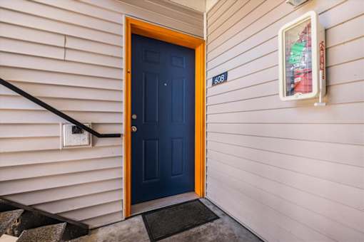 A dark blue door is on the left and a white box is on the right.