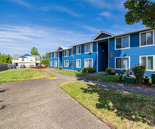 A blue building with a driveway in front of it.