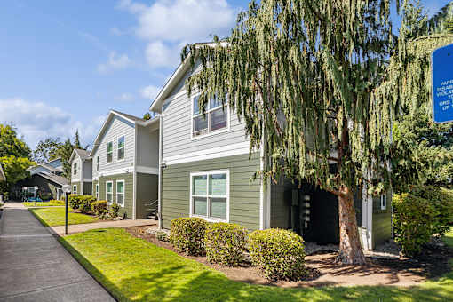 A row of houses with a sign in front of the first one.