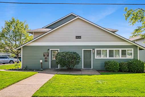 A house with a grey front and a green door.