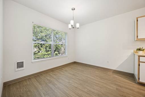 A room with a window and a wooden floor.