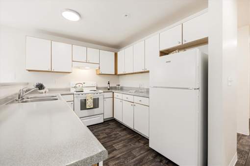 A kitchen with white appliances and cabinets.