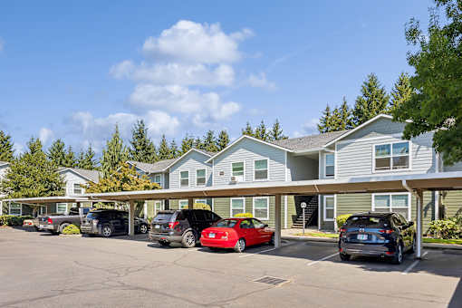A parking lot with cars and a building in the background.