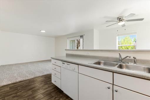 A kitchen with white cabinets and a window.