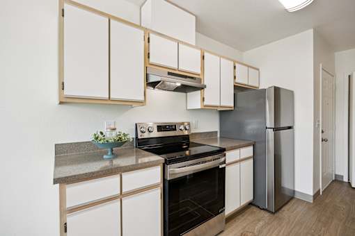 A kitchen with a stove top oven and a refrigerator.