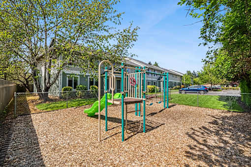 A playground with a green slide and a red slide.