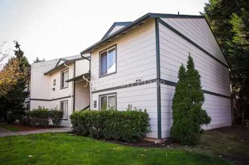 A two-story house with a white exterior and a dark roof.