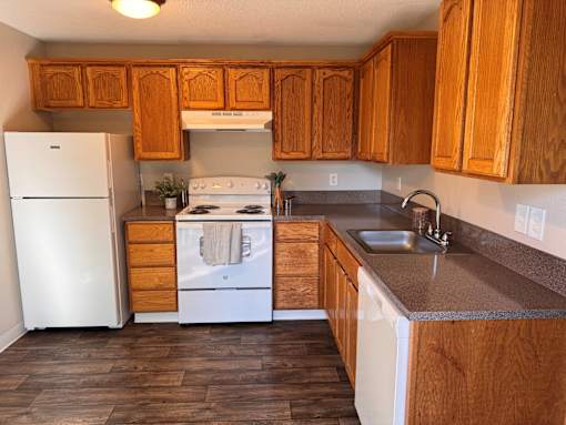 A kitchen with wooden cabinets and a white refrigerator.
