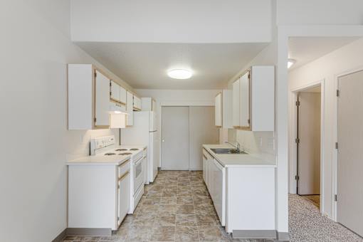 A kitchen with white appliances and cabinets.