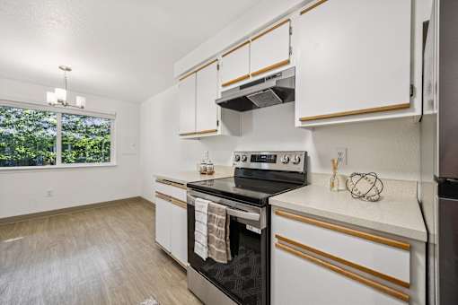 A kitchen with white cabinets and a black stove top oven.