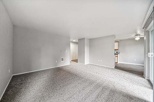 A large, empty room with carpeted flooring and white walls.